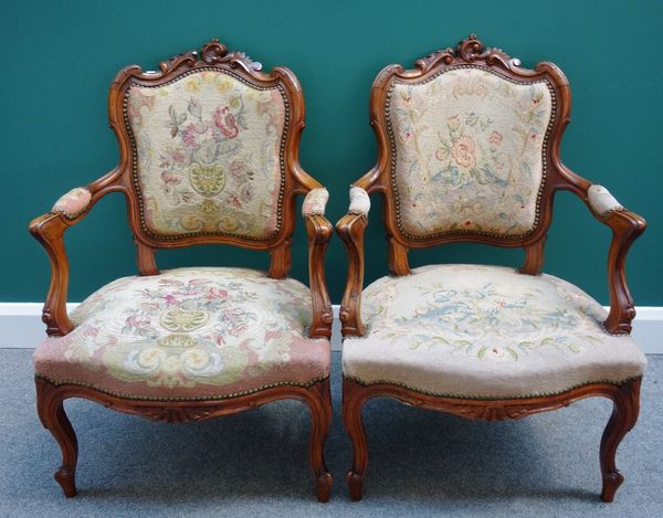 A pair of Louis XV style stained beech open arm fauteuils, with shell carved crest, serpentine seat, and cabriole supports. (2)