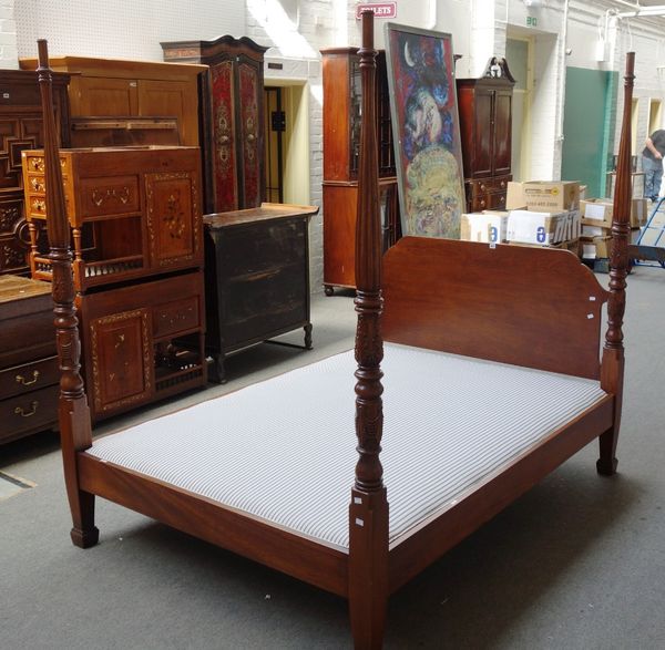 A late 19th century American mahogany four poster bed, with carved head and foot board columns, 154cm wide x 205cm long x 200cm high.