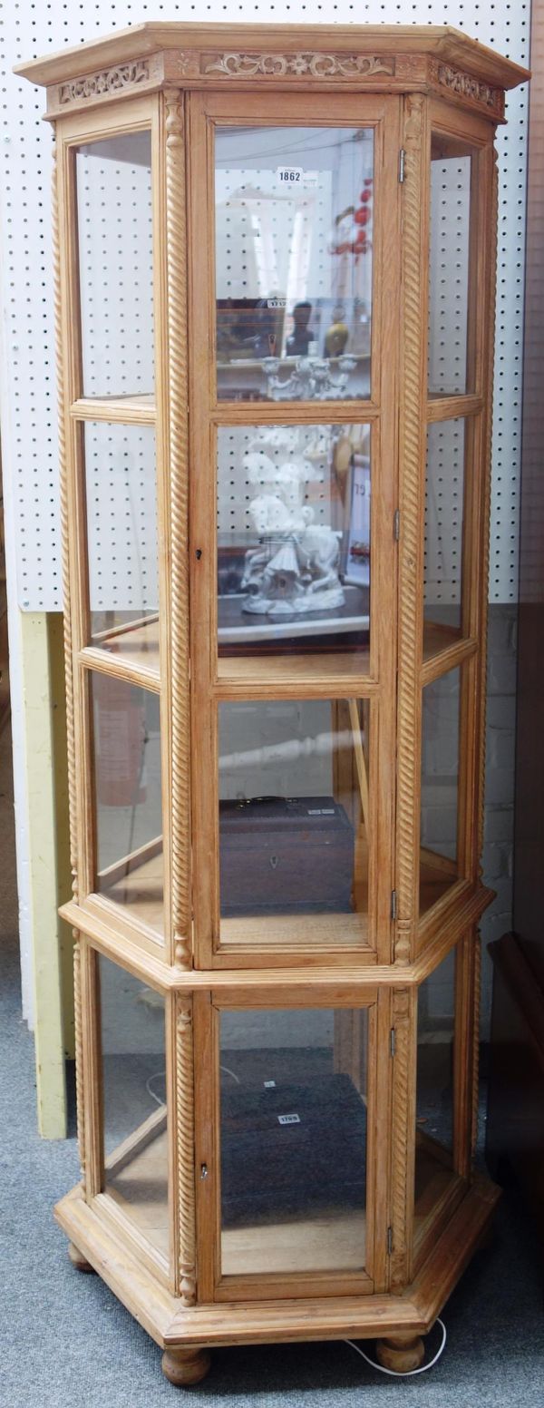 A 20th century limed oak floor standing octagonal four tier display cabinet, 73cm wide x 182cm high.