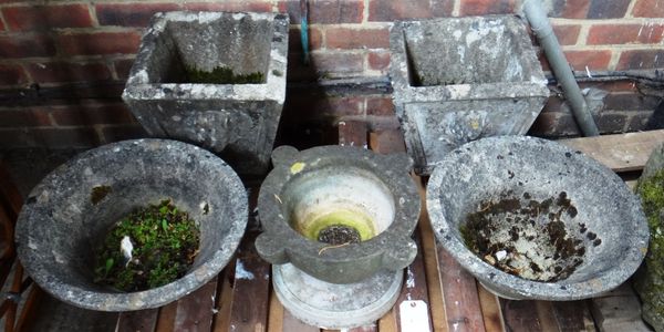 A pair of reconstituted stone tapering square planters, 36cm wide, together with a similar conical pair, 46cm wide, and a carved stone mortar, 42cm wi