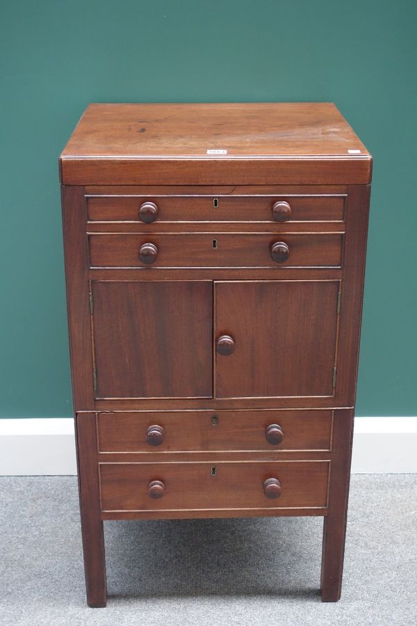 A George III mahogany gentleman's wash stand, the lift top revealing a fitted interior over two dummy drawers, a cupboard and lower pull out box, 51cm