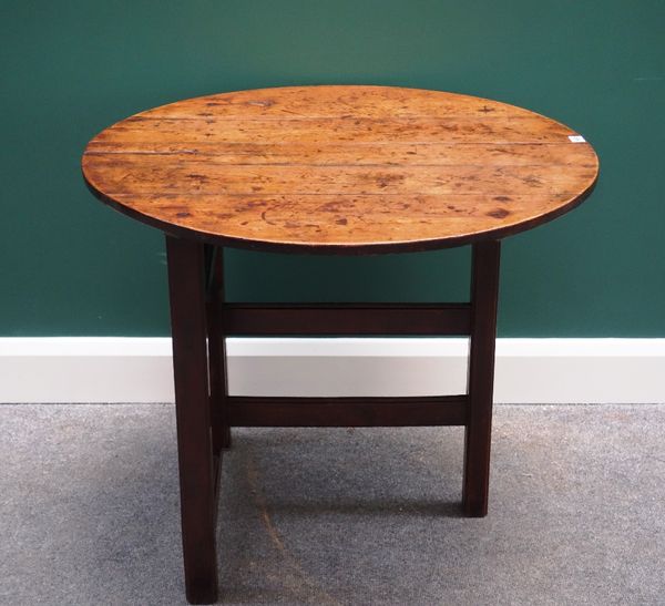 An 18th century fruitwood folding table, the circular plank top on single canted block gateleg supports, 83cm wide.