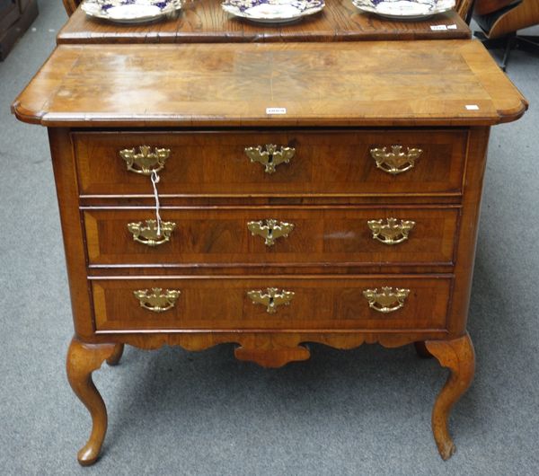 A mid 18th century figured walnut low boy, the three long drawers over shaped frieze, on cabriole supports, 88cm wide.