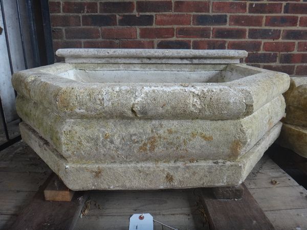 A carved limestone wall fountain, with face mask and canted rectangular design, 105cm wide x 85cm deep.  Illustrated