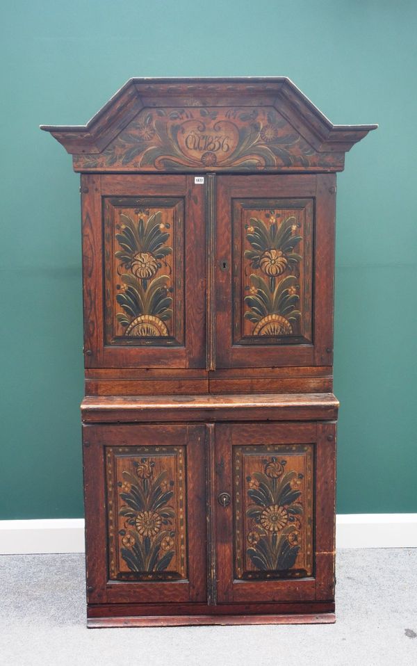 A 19th century North European painted pine cupboard, the bonnet top over two pairs of panel doors, on plinth base, 111cm wide x 190cm high.