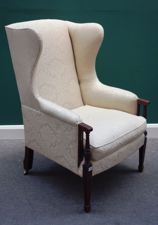 An early 19th century wing back armoire, on turned and square tapering mahogany supports.