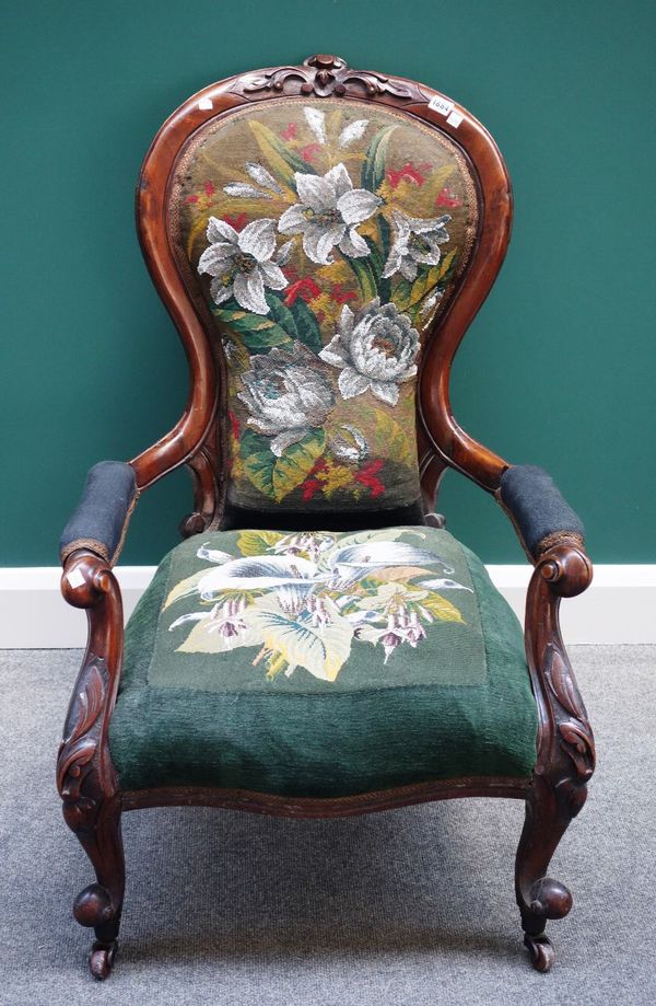 A Victorian mahogany framed spoon back open armchair, with serpentine seat, on scroll supports.