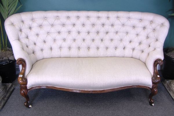 A Victorian mahogany framed button back sofa, with serpentine seat and scroll supports, 190cm wide.