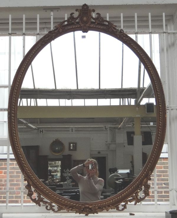 A large Victorian oval gilt framed wall mirror, with cartouche carved crest and rope twist frame, 115cm wide x 152cm high.