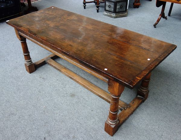 A 17th century style oak refectory table, the cleated plank top on turned supports, united by stretcher, 183cm long x 76cm wide.