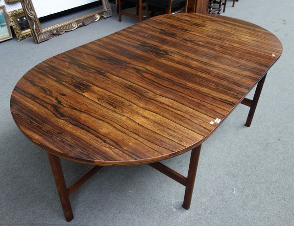 Archie Shine; a mid 20th century rosewood circular extending dining table, on four double rounded rectangular supports, united by 'X' frame stretcher,