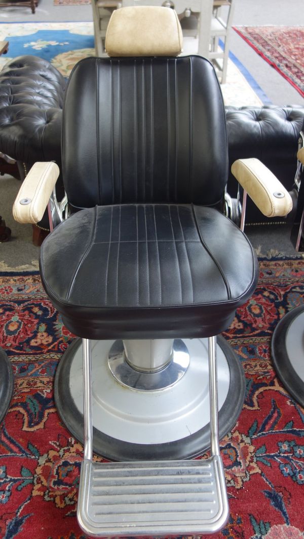 Takara Belmont Product of Japan; a mid 20th century cream and black leatherette upholstered barber's chair, with height adjustment column and angled b