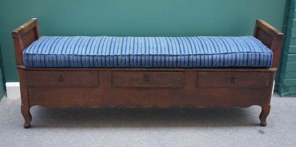 An 18th century and later French oak settle, with panelled ends on block supports and three frieze drawers, 187cm wide.