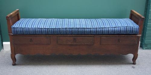 An 18th century and later French oak settle, with panelled ends on block supports and three frieze drawers, 187cm wide.
