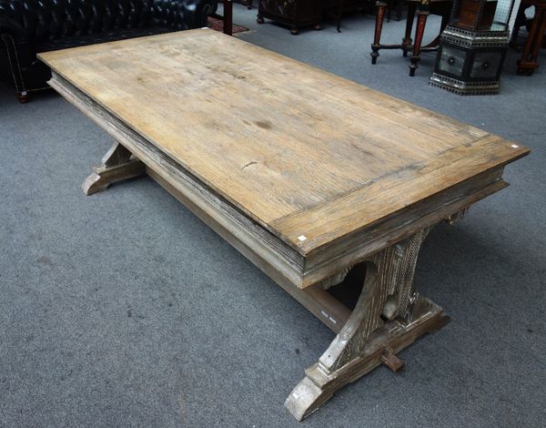 A 17th century style limed oak refectory table, on pierced trestle end standards, united by stretcher, 100cm wide x 200cm long.