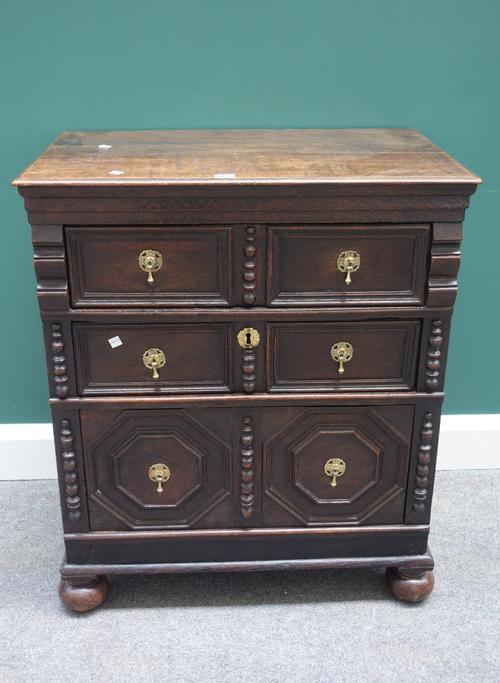 A 17th century and later small oak chest of three long graduated drawers, with split bobbin and geometric moulding, 74cm wide x 85cm high.