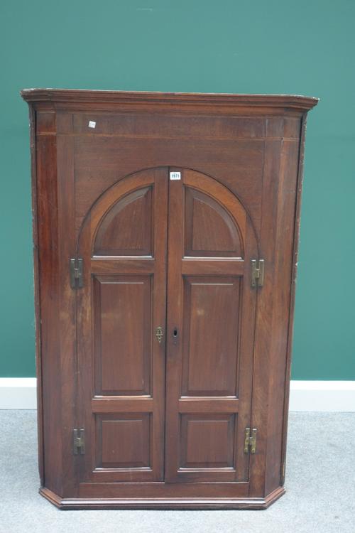 A George III mahogany hanging corner cupboard, with pair of arch top panel doors, 95cm wide.