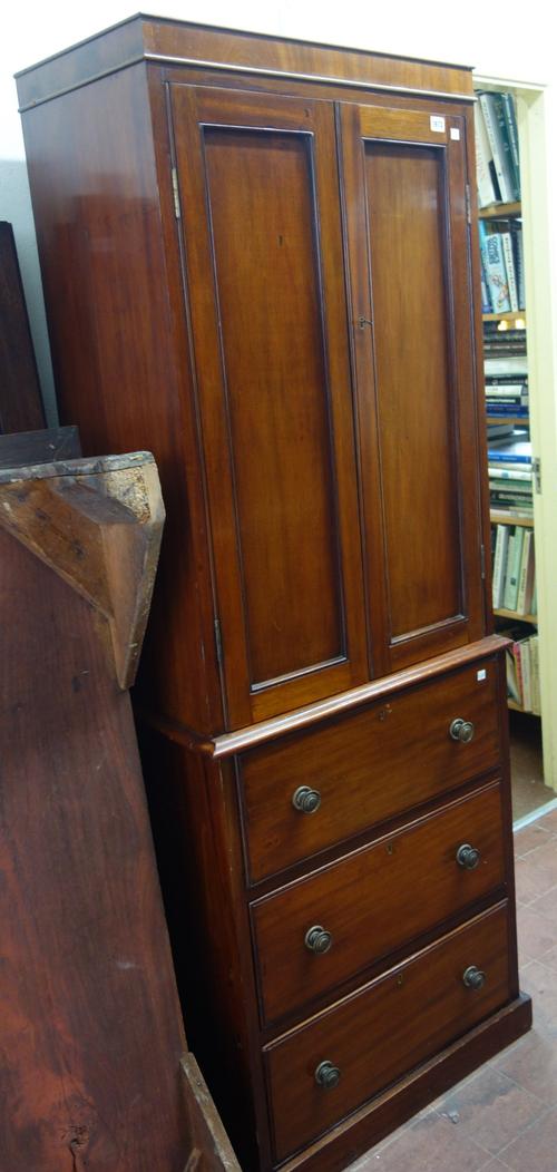 A small early 19th century mahogany linen press, with pair of panel doors on a plinth base, 64cm wide x 185cm high.