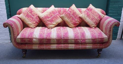 An early 19th century mahogany framed sofa, with roll over ends on turned supports, 225cm wide, together with a matching copy, (2).