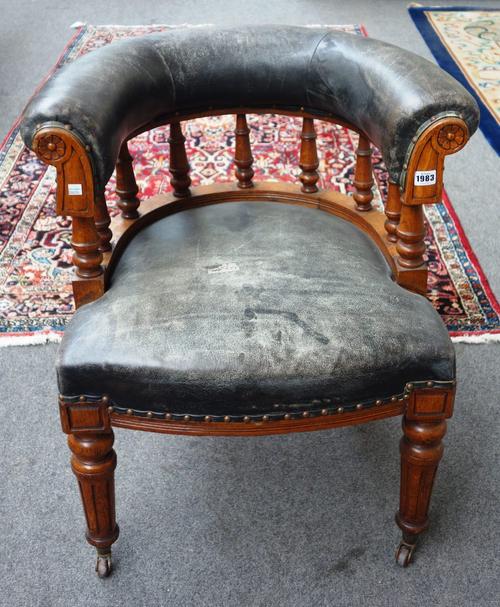 A Victorian oak and leather upholstered tub back office chair, with bow seat on tapering fluted supports.