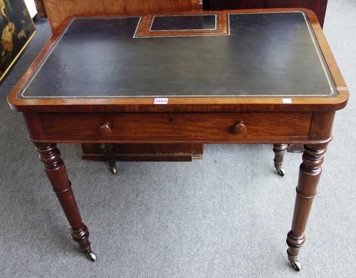 In the manner of Gillows; an early 19th century mahogany writing table, the leather inset top with flip-up panel, revealing a fitted interior over sin
