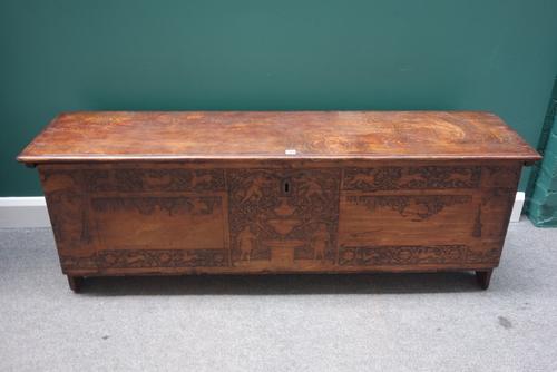 A Cypress chest, the rectangular lift top over carved front panel, on slab end supports, the front panel possibly 17th century, 166cm wide.