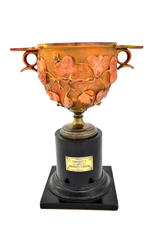 A Victorian silver gilt twin handled trophy cup, modelled as a vase after the antique, the body decorated with foliate sprays, on a stippled ground wi