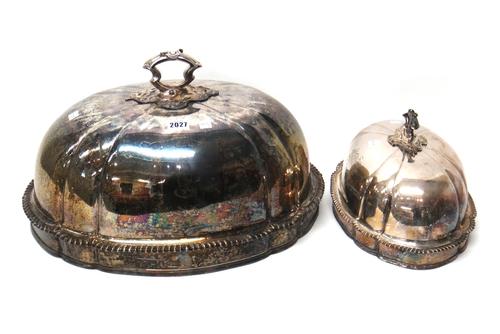 Two graduated plated on copper Victorian meat domes, each of shaped oval form, decorated with a gadrooned rim and with a detachable carrying handle, (