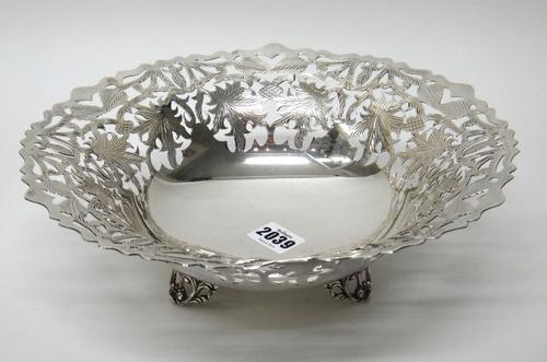 An Egyptian shaped circular bowl, having pierced and engraved decoration within a shaped border, raised on three cast scroll pierced feet, diameter 28