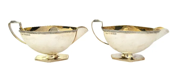 A pair of Art Deco silver sauceboats, each with an angular handle, decorated rim and on a hexagonal foot, by Mappin & Webb, Birmingham 1934, combined