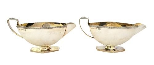 A pair of Art Deco silver sauceboats, each with an angular handle, decorated rim and on a hexagonal foot, by Mappin & Webb, Birmingham 1934, combined