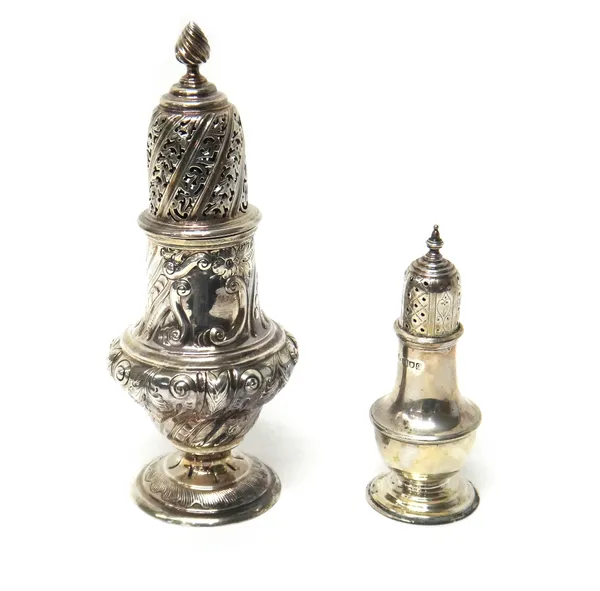 A Victorian large silver table sugar caster, London 1886, with embossed foliate and scroll decoration and simulated flame finial, and a silver peppere