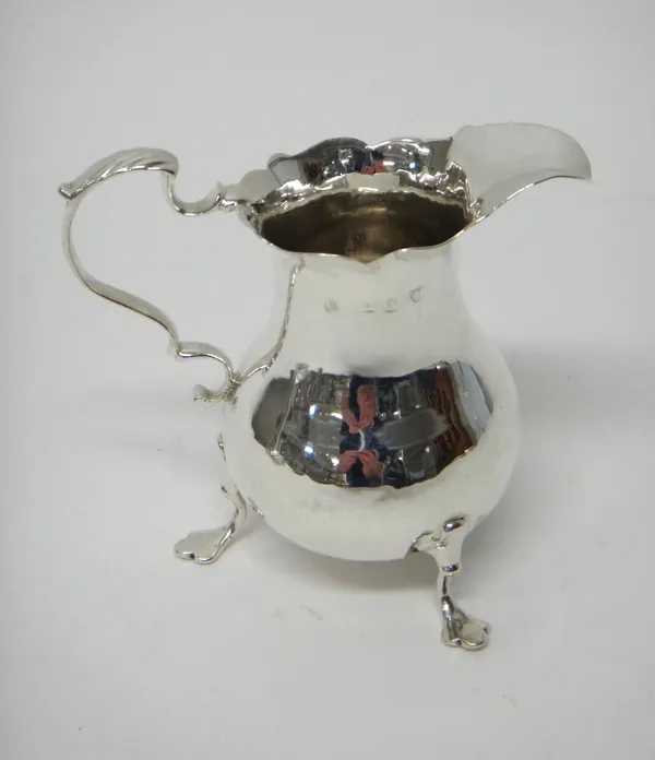 A George III silver cream jug, of pear shaped form, having a scrolling handle and raised on three pad feet, London 1765, weight 72 gms.