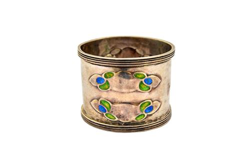 A silver and enamelled Art Nouveau napkin ring, decorated with blue/green enamelled cloud shaped motifs between ridged edges, Birmingham 1902, gross w