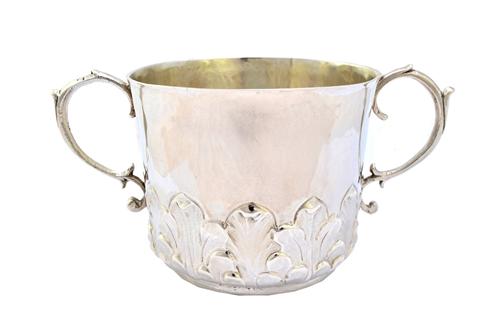 A Charles II silver twin handled porringer, chased with a band of acanthus foliage and with scrolling handles, the base engraved with the initials S L