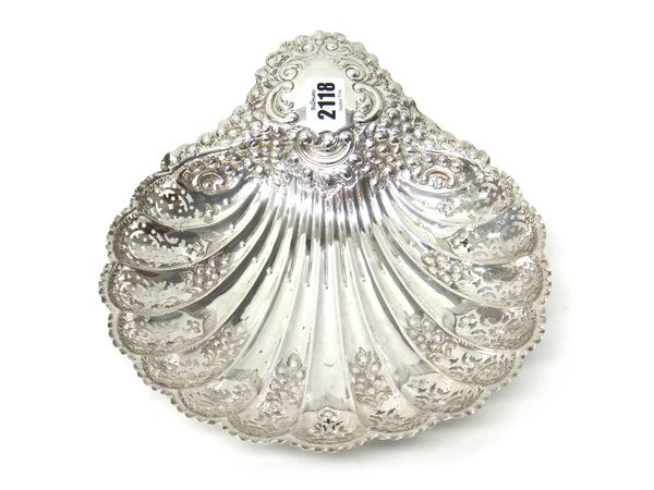 A silver biscuit dish, of scallop shell shaped form, with floral, foliate and pierced decoration, raised on three fluted spherical feet, Sheffield 190