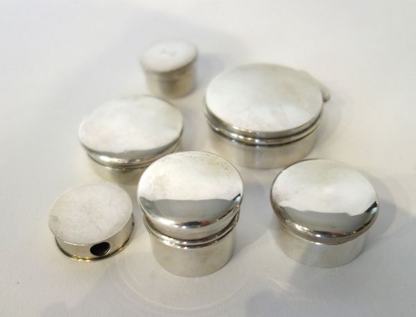 A silver hinge lidded circular box, gilt within, the exterior plain, Birmingham 1912, a silver circular dispensing pill box, Chester 1917 and four fur