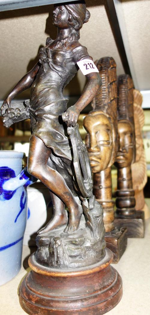 A bronze figure modelled as a lady, holding a harp and a bowl, together with four African hardwood carved figures, (5).