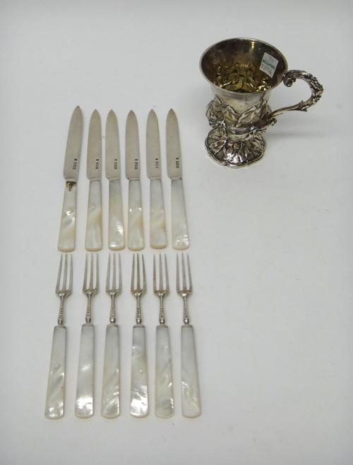 A William IV silver christening mug, London 1830, with embossed leaf decoration and foliate capped scroll handle, presentation inscribed, and a set of