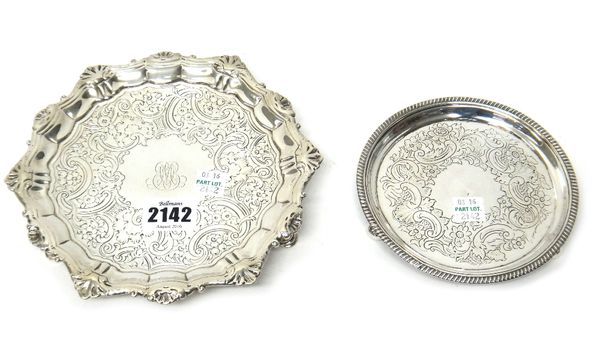 Silver, comprising; a George II shaped circular salver, with later floral and scroll embossed decoration within a moulded rim, raised on three pad fee