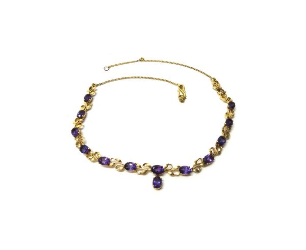 A gold and amethyst necklace, the links in a foliate design, claw set with oval cut amethysts and with an amethyst set single stone drop, on an 'S' sh