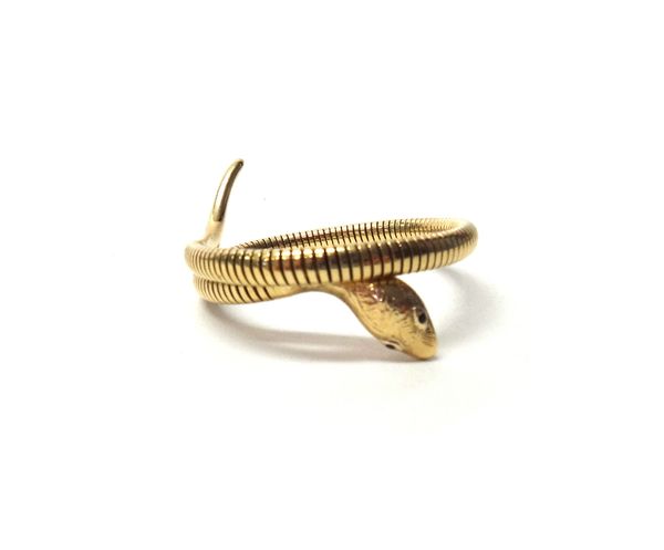 A 9ct gold bracelet, designed as a coiled serpent with red gem set eyes, Chester 1958, gross weight 20.5 gms.