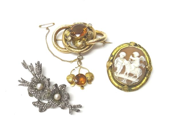 A Victorian gold and citrine set brooch, of shaped oval entwined design, with foliate motifs and with a circular cut citrine mounted to the centre, th