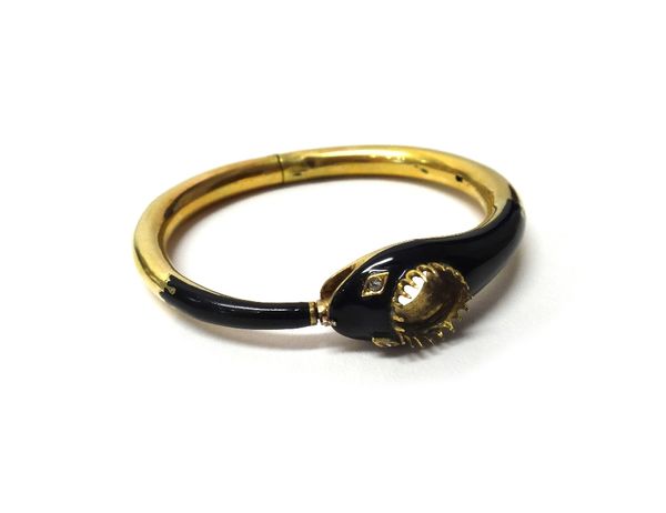 A gold and black enamelled hinged bangle, designed as a snake, the head and the tail end black enamelled and with rose diamond set eyes, the principal