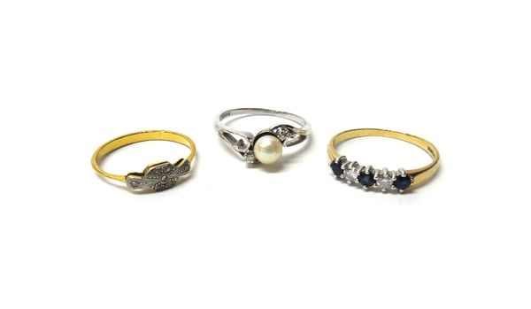 An 18ct white gold ring, mounted with a central cultured pearl, between two cushion shaped diamonds, in a scrolling crossover design, a gold and diamo