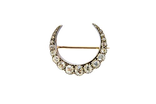 A Victorian silver fronted and gold backed diamond brooch, designed as a crescent, mounted with a row of cushion shaped diamonds, graduating in size t