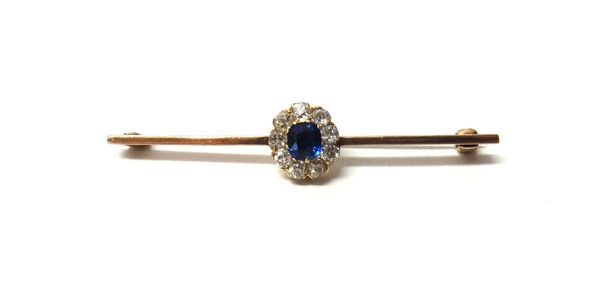 A gold, sapphire and diamond set cluster bar brooch, claw set with the cushion shaped sapphire at the centre, within a surround of nine cushion shaped