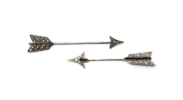 A diamond and black onyx set jabot pin, designed as an arrow and another diamond set jabot pin, designed as an arrow, mounted with rose cut diamonds,