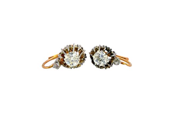 A pair of diamond set two stone drop earrings, each claw set with the principal cushion shaped diamond below a smaller rose cut diamond, with a case.