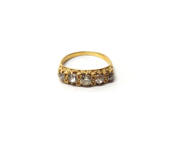 A gold and diamond set five stone ring, mounted with a row of cushion shaped diamonds graduating in size to the centre stone, the mount with scroll pi